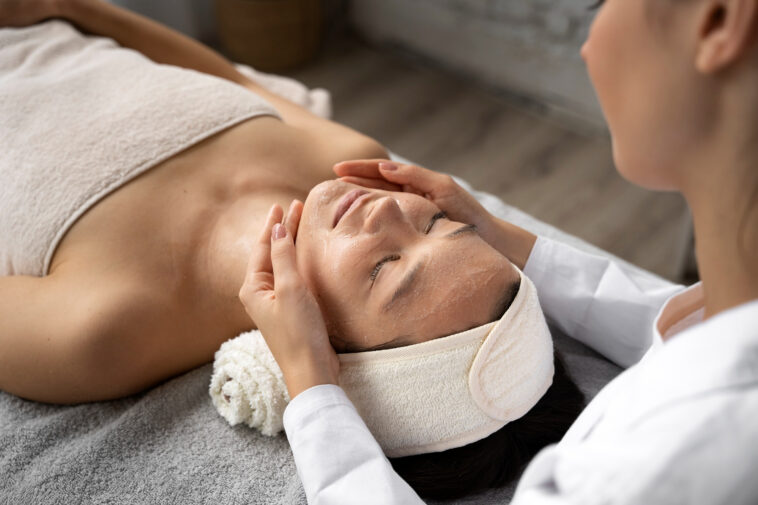 Woman relaxing on a massage table getting a skincare facial massage. Skinworks Skinsolutions Vitaltiy and Wellness