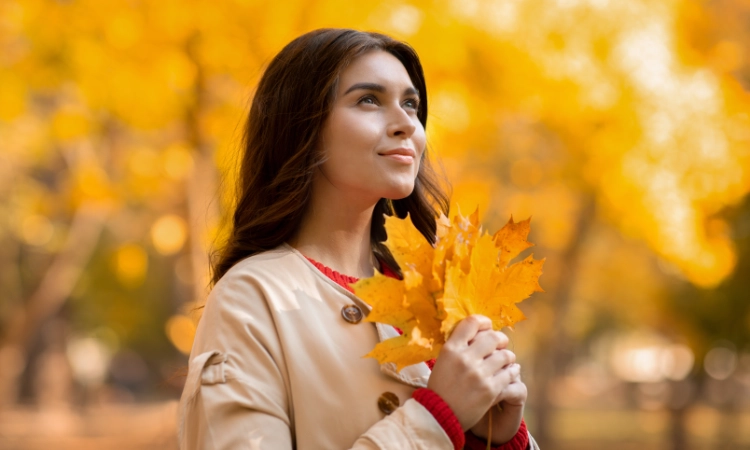 woman in stylish fall coat with a good fall skincare routine